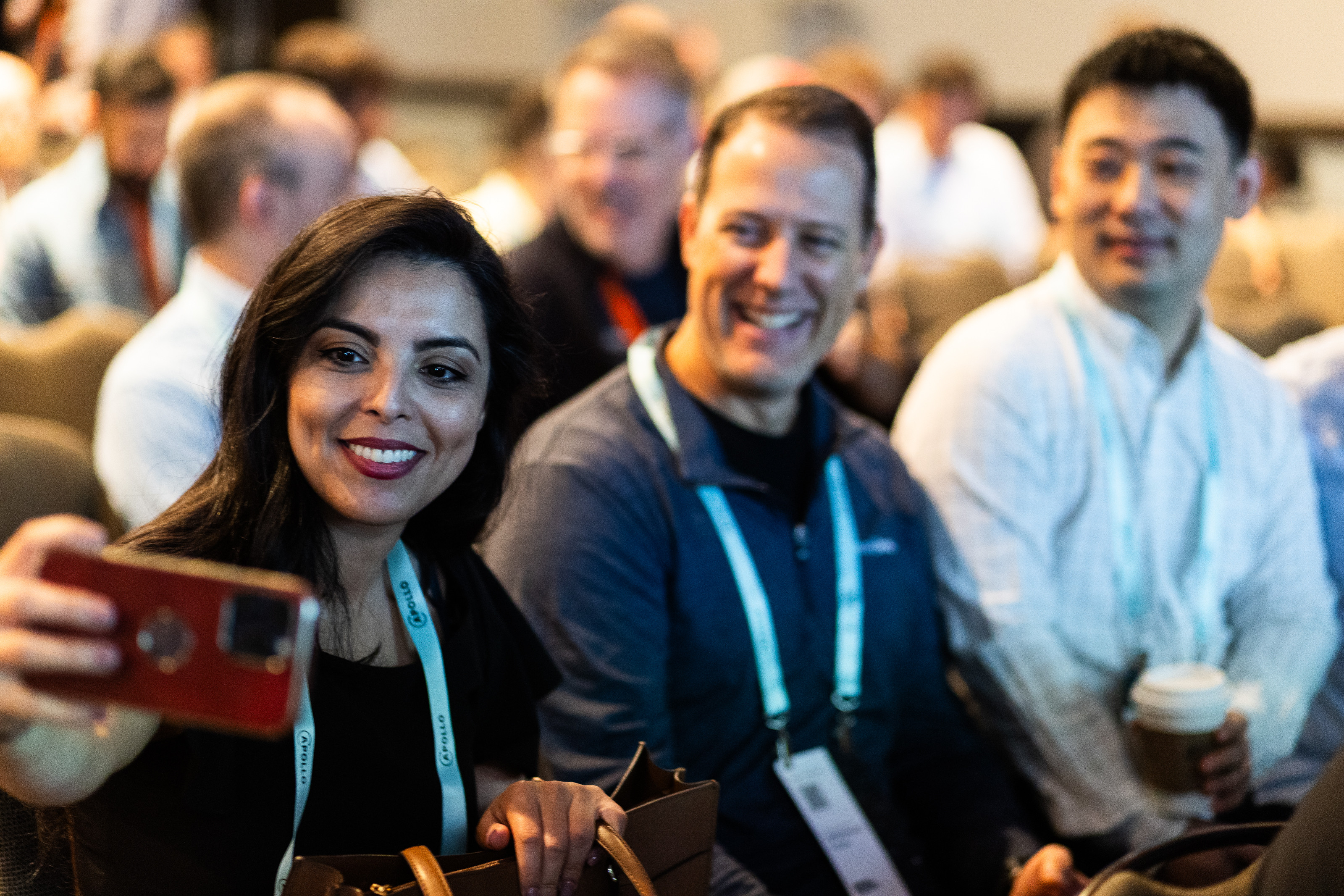 A group of attendees laughing together while taking a selfie at Summit.